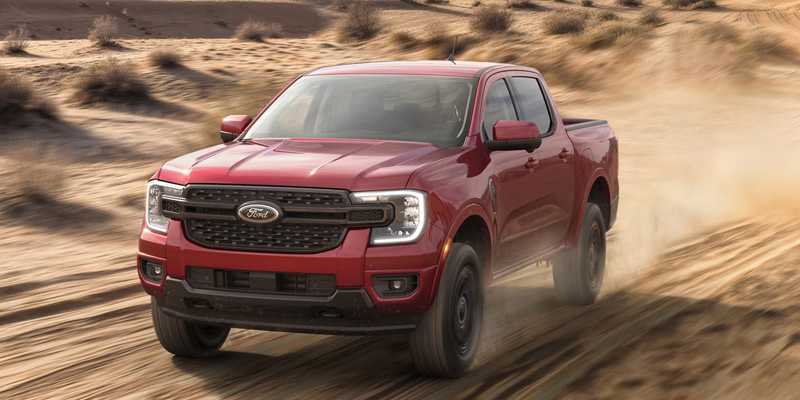 Red Ford Ranger driving through sand.